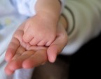 La mano del piccolo Vincent di 1 mese, nella mano di Federica, la primogenita, 8 anni.