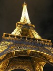 Visione notturna ai piedi della torre Eiffel illuminata.