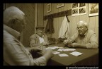 Anziani in una societ operaia durante un'accanita giocata a carte.