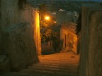 Modica (che meraviglia di citt!) scendendo dal belvedere di Pizzo verso la cattedrale di San Giorgio. Foto eseguita nel 2004 con digitale compatta Canon Ixus 400. Temo tanto che abbiano "rimodernato" l'intera zona illuminandola fortemente e restaurando e riimbiancando i muri; ritornandovi a due anni di distanza armato di tutto punto non ho pi saputo trovare questo angolino incantevole. Era settembre, c'era caldo e profumo di fichi maturi, ma questo la foto non lo dice ...