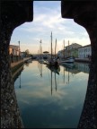 un trompe l'oeil, il porto canale di Cesenatico che da una visuale insolita diventa un'anfora dipinta di mare e di antichi velieri..