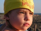 Una bimba in spiaggia che guarda il mare e la spiaggia prima del rientro dalle vacanze.