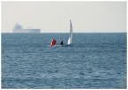 L'entrata in porto di una piccola barca a vela e di una petroliera...