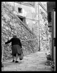 Una signora anziana con borsa della spesa in un paese della Toscana