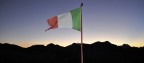 un soffio al tramonto gonfia la bandiera. Poco oltre il confine italo-francese