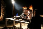 Durante un party sulla spiaggia di Maccarese (Roma) inservienti preparano due grossi pescispada per la griglia. Una donna guarda.