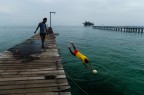 Ragazzi dell'etnia dei Bajau Laut o volgarmente definiti Nomadi Del Mare, giocano a pallone sul molo.