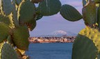 L'Etna vista dall'Area Marina Protetta del Plemmirio con all'orizzonte l'isola di Ortigia (Siracusa)