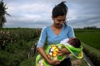 Bali, Indonesia. A young girl with her baby, near home.