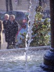 Passeggianti dietro gli spruzzi di una fontana